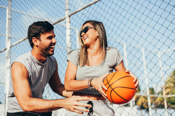 istock Couple having fun playing basketball outdoors on sunny day. 1257288598