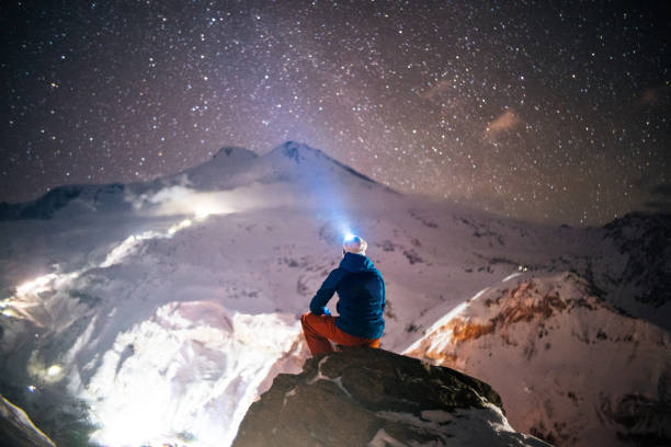 l’alpiniste se détend sur le pinacle de montagne la nuit - mountain peak snow mountain winter photos et images de collection
