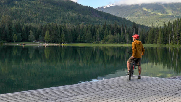 istock Mountain e-biker relaxes on lakeside pier 1257292253