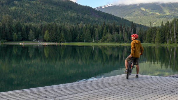 istock Mountain e-biker relaxes on lakeside pier 1257292298