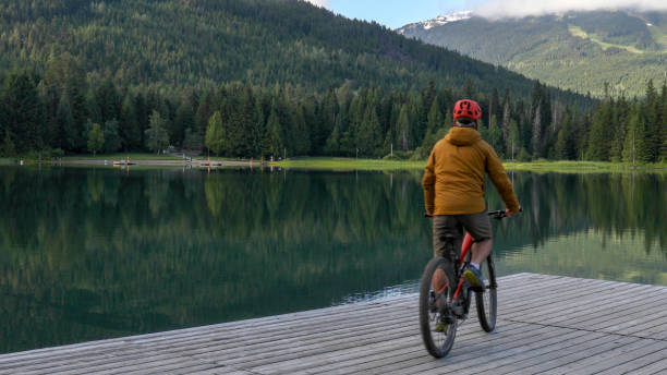 istock Mountain e-biker rides along lakeside pier 1257292923