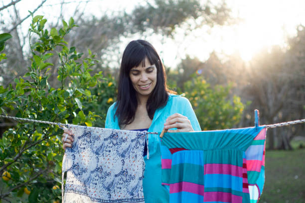 istock woman hanging up her clothes 1257293147
