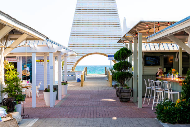 Seaside beach town Florida panhandle with white architecture of Obe pavilion tower and restaurant shops Seaside, USA - April 25, 2018: Park in city town beach village during sunny day in Florida panhandle with white architecture of Obe pavilion tower and restaurant shops new urbanism stock pictures, royalty-free photos & images