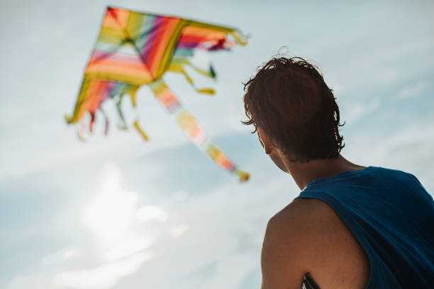 istock Teenage boy flying kite on beach 1257293873