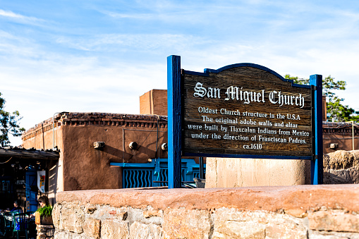 Santa Fe, USA - June 14, 2019: San Miguel Mission chapel oldest church in the United States information sign with adobe architecture