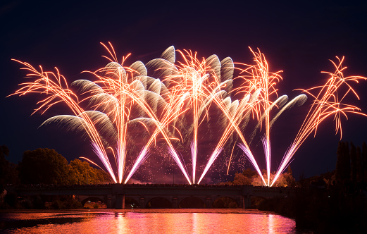 View of the fireworks on stoned bridge on the Orb River with reflection in Beziers in France
