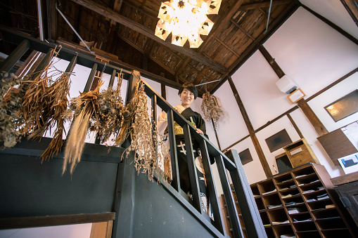 Japanese woman in yukata standing on stairs in traditional Japanese ‘Ryokan’ hotel