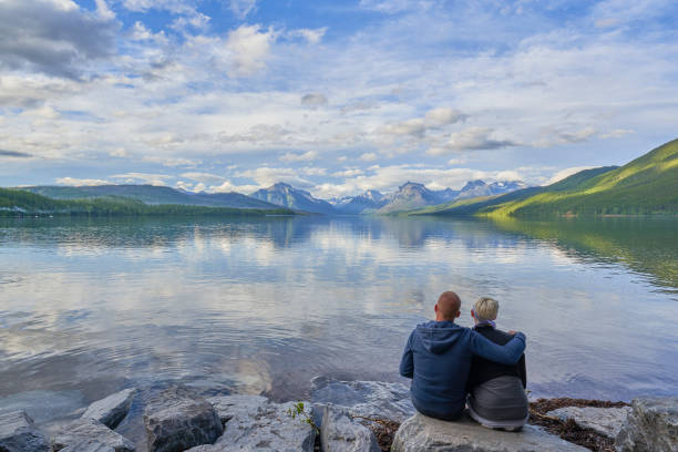 couples regardant le beau paysage naturel de la région du lac mcdonald du parc national des glaciers pendant l’été dans le montana, etats-unis. - montana us glacier national park glacier scenics photos et images de collection