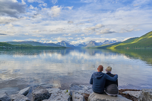 Couple looking at the beautiful natural scenery of Glacier National Park's Lake McDonald area in Montana, USA.