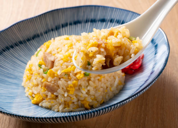 Scoop the fried rice with a Chinese soup spoon Scoop the fried rice with a Chinese soup spoon fried rice stock pictures, royalty-free photos & images