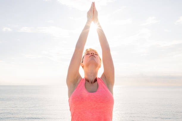 istock woman meditating and practicing yoga at sunrise 1257300390