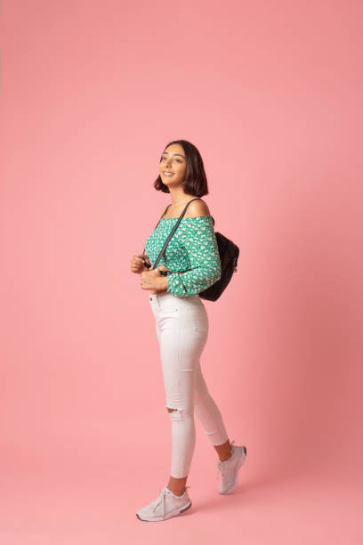 istock Beautiful student girl is walking wearing backpack. 1257303635