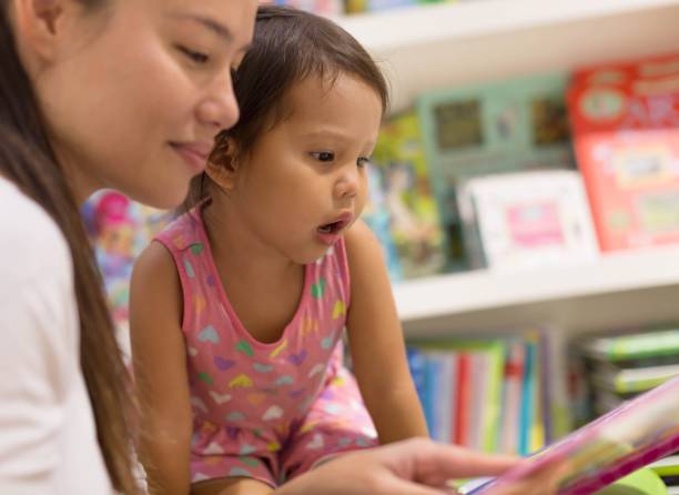 istock Little kid reading books with her parent. 1257305718