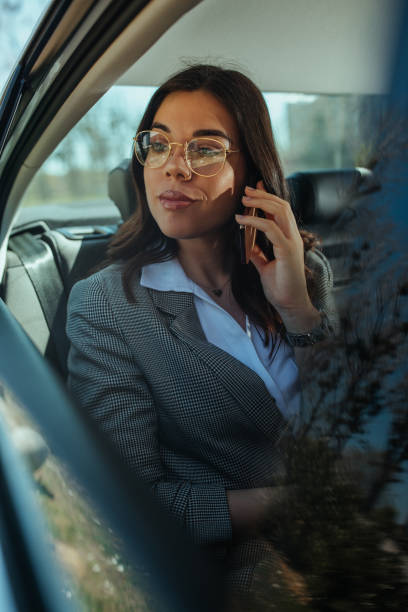 перемещение ходов, сидя в пробках - luxury car women smart phone стоков�ые фото и изображения