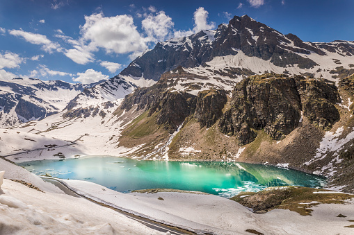 Mountain road and Lake Agnel , snowcapped landscape – Gran Paradiso, Italy