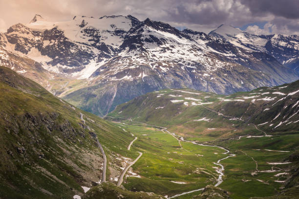 mountain road and alpine landscape in col de l'iseran mountain pass - french alps - sunrise european alps mountain alpenglow imagens e fotografias de stock