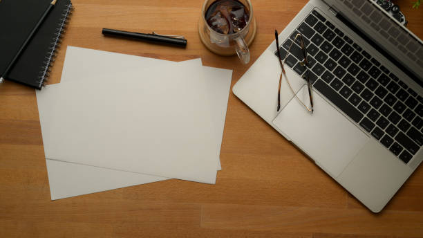 istock Rustic workspace with laptop, papers, pen, schedule book, coffee cup and glasses 1257319258