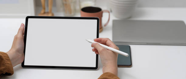 istock Female using mock up tablet with stylus pen on white table in home office 1257319807