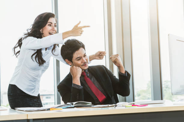 istock Two happy business people celebrate at office 1257320067