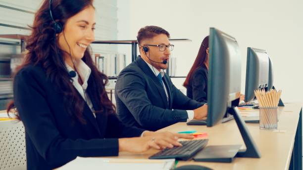 istock Business people wearing headset working in office 1257321354