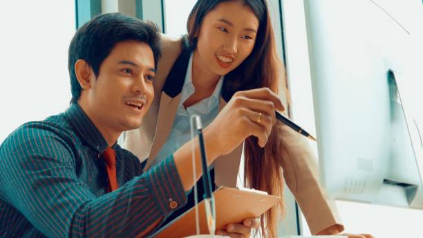 istock Two business people talk project strategy at office 1257321412