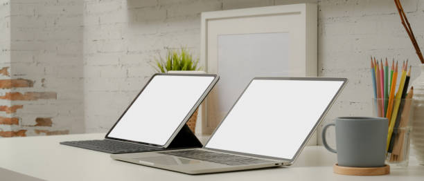 istock Mock up laptop and digital tablet with keyboard on modern worktable with stationery and decorations 1257321522