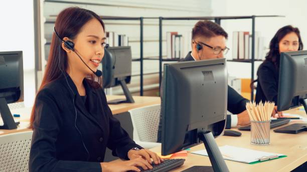 istock Business people wearing headset working in office 1257324723