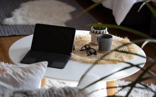 istock Working from home laptop coffee table cushions and reading glasses 1257324845