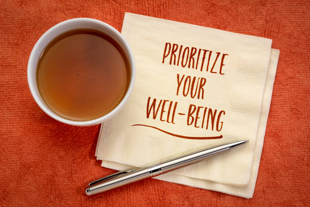 prioritize your well-being inspiraitonal note prioritize your well-being inspirational note - handwriting on a napkin with a cup of tea, healthcare, healthy lifestyle and personal development concept body care stock pictures, royalty-free photos & images