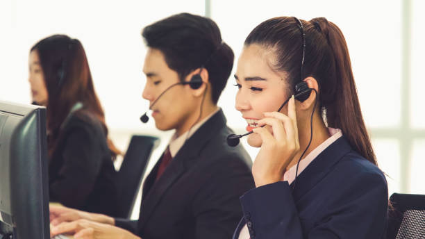 istock Business people wearing headset working in office 1257329612