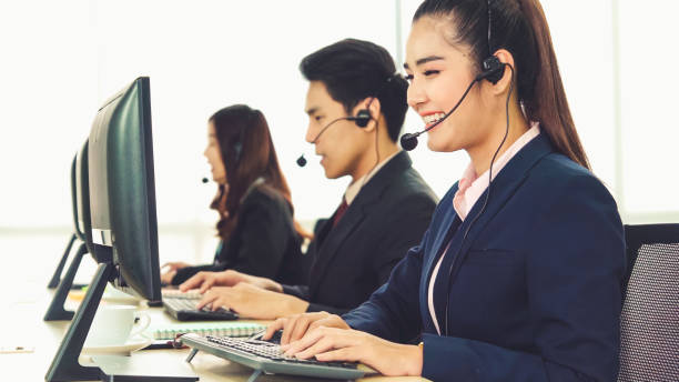 istock Business people wearing headset working in office 1257330896