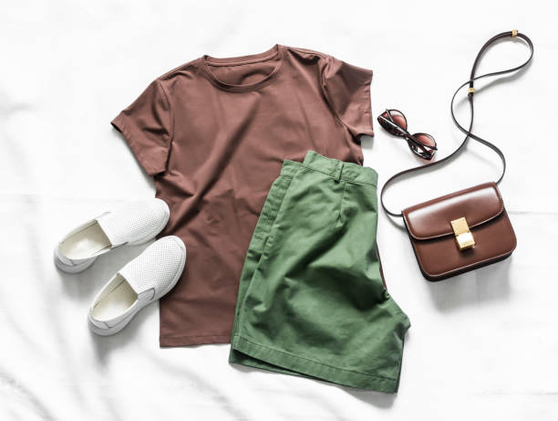 women's cotton bermuda shorts, brown t-shirt, crossbody bag, white leather sneakers on a light background, top view. fashion concept - belt personal accessory leather fashion imagens e fotografias de stock