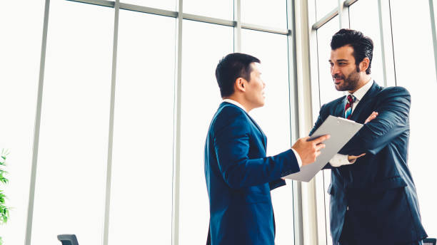 istock Two business people talk project strategy at office 1257331657