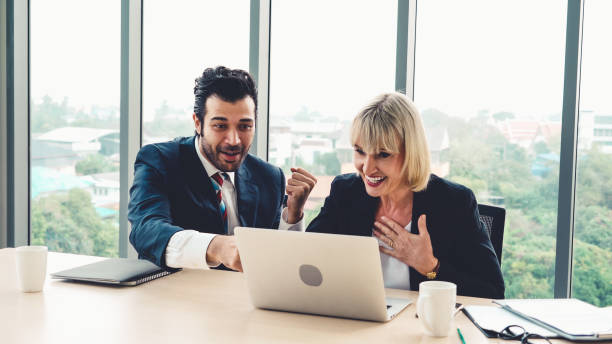 istock Two happy business people celebrate at office 1257333607