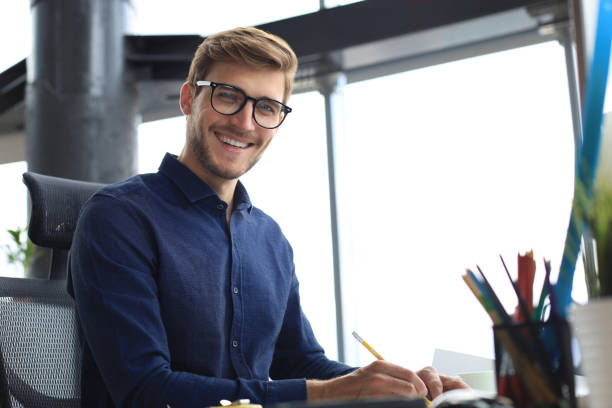istock Good looking young business man drawing something while working in the office. 1257335274