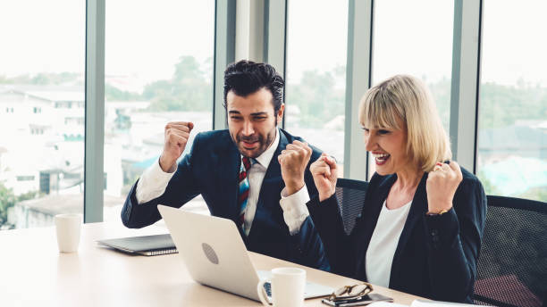 istock Two happy business people celebrate at office 1257335952
