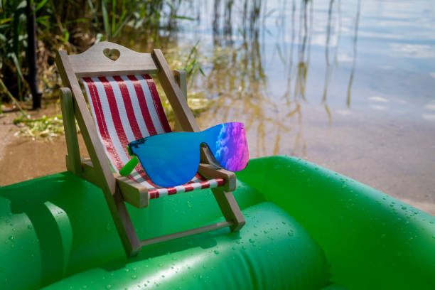 istock Sunglasses on a small striped deck chair 1257335973