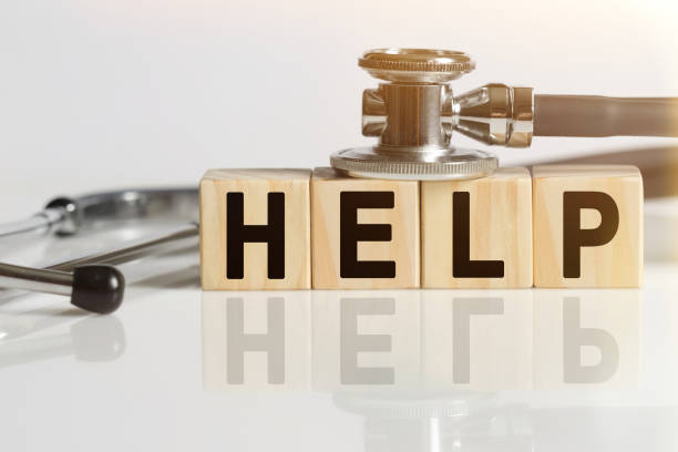 istock HELP the word on wooden cubes, cubes stand on a reflective white surface, on cubes - a stethoscope. 1257339142