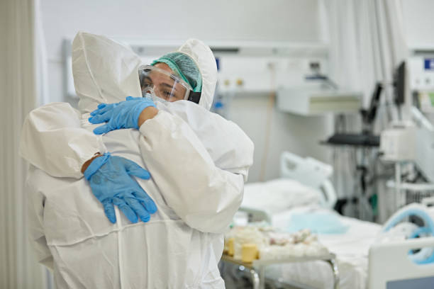 istock Medical Teammates in Protective Suits Embracing in Support 1257342887