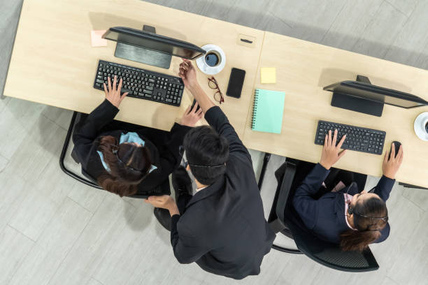 istock Business people wearing headset from top view in office working with computer 1257343226