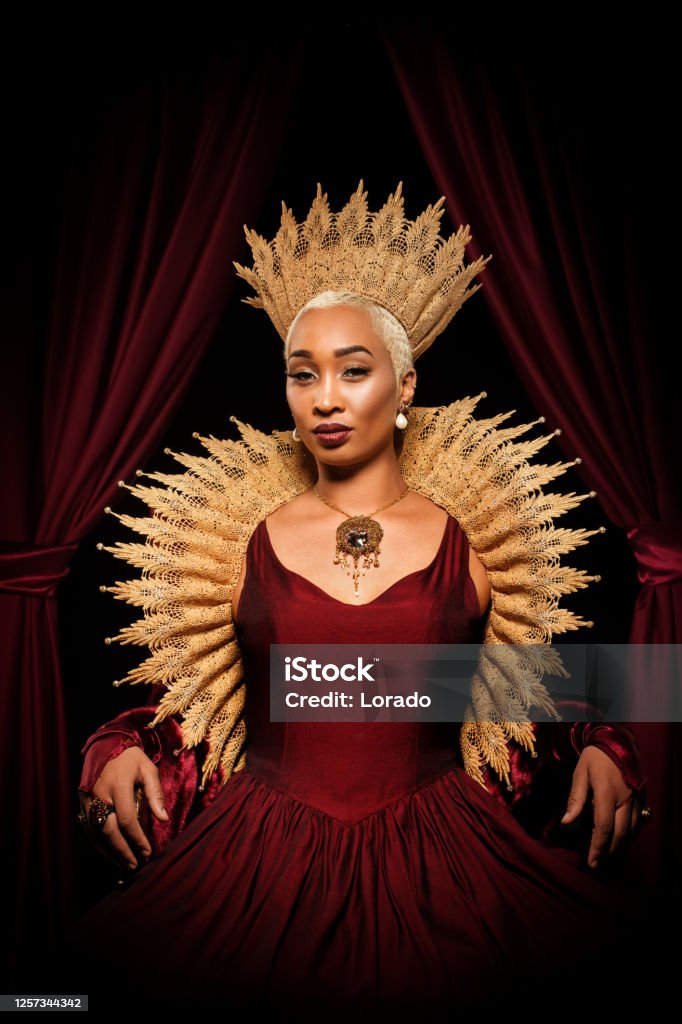 Historical mixed race Queen character on the throne Beautiful mixed race historical african Queen character wearing a period dress in a studio shot Queen - Royal Person Stock Photo
