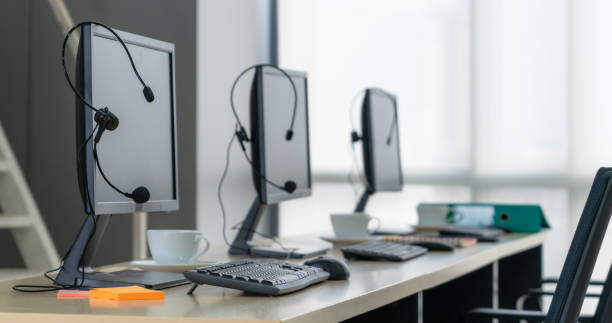 istock Call center computers and headsets all in office 1257345382