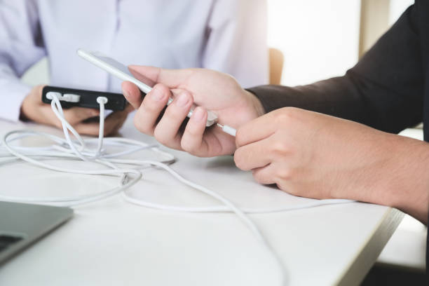 istock people using power bank charge to mobile phone. Tech Device Charge Sharing Concept. 1257347228
