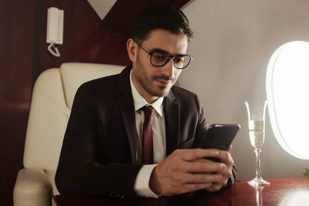 istock Rich businessman or billionaire flying first class and working on plane, using phone. Private jet and luxury lifestyle 1257348625