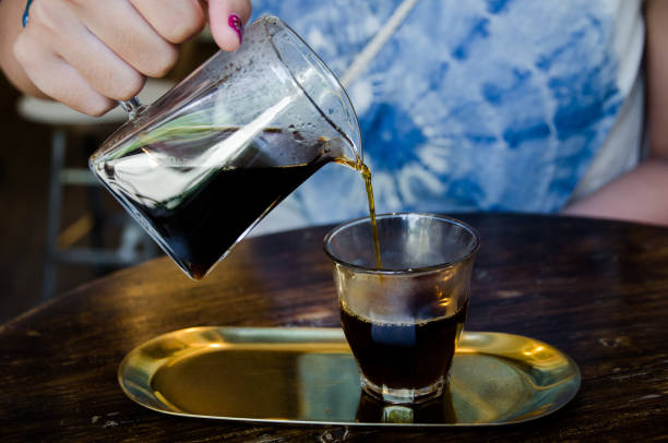 istock female hand is pouring coffee in glass 1257351678