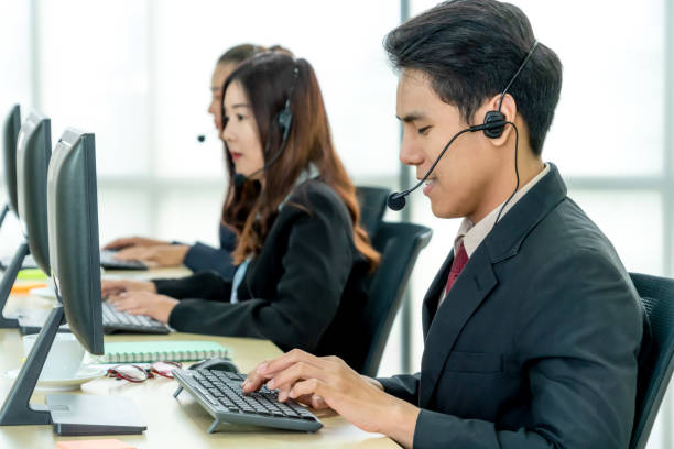 istock Business people wearing headset working in office 1257351922