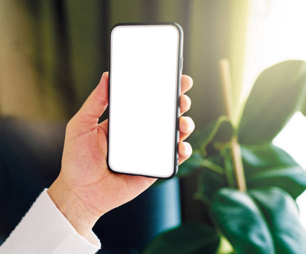 istock Woman holding and touching blank screen template smart phone. Smart phone screen is empty. 1257354340