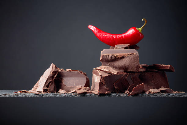 Black chocolate with red pepper on a dark background. Copy space.