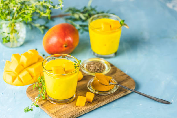 jaune indien yaourt mangue boisson mango lassi ou smoothie au curcuma et safran - boisson exotique photos et images de collection