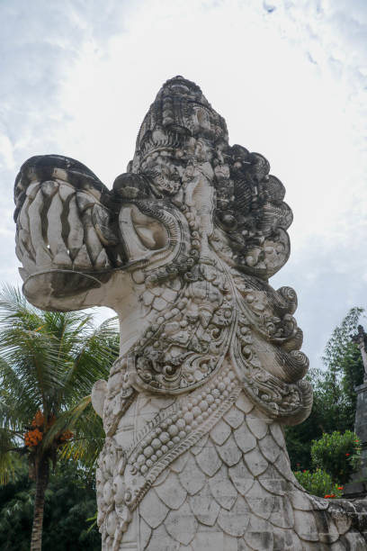 レンプヤン寺院の入り口の前にある神話のドラゴンの顔 - 伝統的なインドネシアの芸術とバリのヒンズー教の宗教の象徴。バリの人々の文化とアジアの旅行の背景 - bali balinese culture art carving ストックフォトと画像